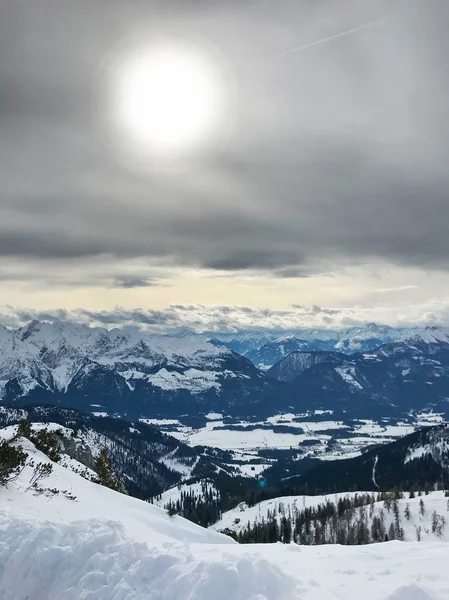 雲を通して輝く太陽と美しい雪山の静かなショット — ストック写真