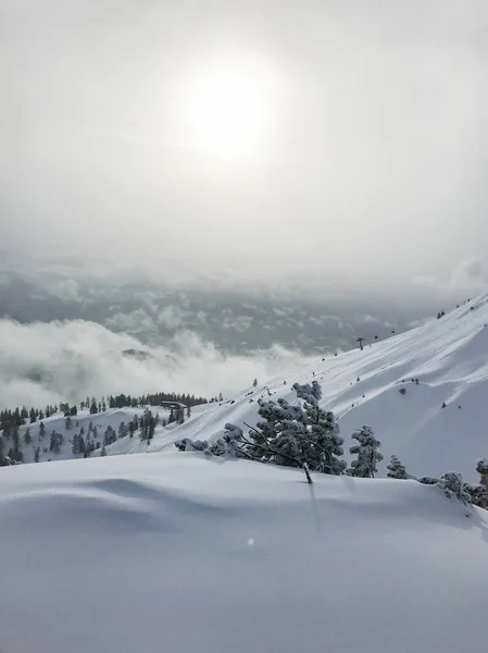Спокойный Снимок Красивых Снежных Гор Солнцем Сияющим Сквозь Облака — стоковое фото