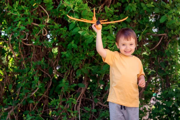 Kleinkind Spielt Solo Mit Orangefarbenem Spielzeugflugzeug Garten Oder Hof Green — Stockfoto
