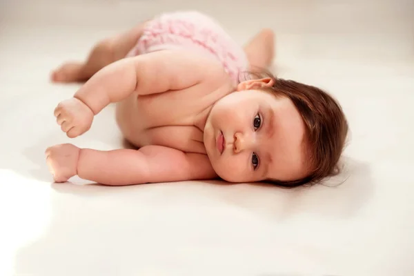 幼児の毛布をオンにすることを学ぶ 真面目な表情をした赤ん坊の少女の肖像が横になって腹に転がろうとしている 健康的な開発コンセプト スペースのコピー — ストック写真