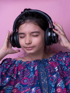 Eğlenceli genç çocuk kulaklıkla müzik dinleyerek ritim tutuyor. Ritmi yakala. Çocuk müzik kulaklığı dinliyor. Eğlence ve eğlence. Yaz çalma listesinin tadını çıkar. En sevdiğim şarkı. Çocuklar Günü. 