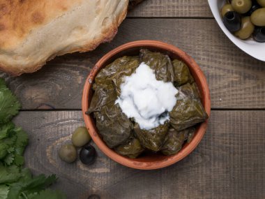Geleneksel Azerbaijan dolması, kopyalanmış kırsal ahşap masa üzerinde üzüm yaprakları içinde. Doğu yemeği. Asma yapraklarındaki geleneksel Gürcü tolma, kopyalanmış kırsal arka planda. Türk yemeği