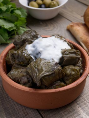 Geleneksel Azerbaijan dolması, kopyalanmış kırsal ahşap masa üzerinde üzüm yaprakları içinde. Doğu yemeği. Asma yapraklarındaki geleneksel Gürcü tolma, kopyalanmış kırsal arka planda. Türk yemeği
