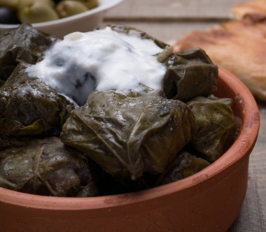 Geleneksel Azerbaijan dolması, kopyalanmış kırsal ahşap masa üzerinde üzüm yaprakları içinde. Doğu yemeği. Asma yapraklarındaki geleneksel Gürcü tolma, kopyalanmış kırsal arka planda. Türk yemeği