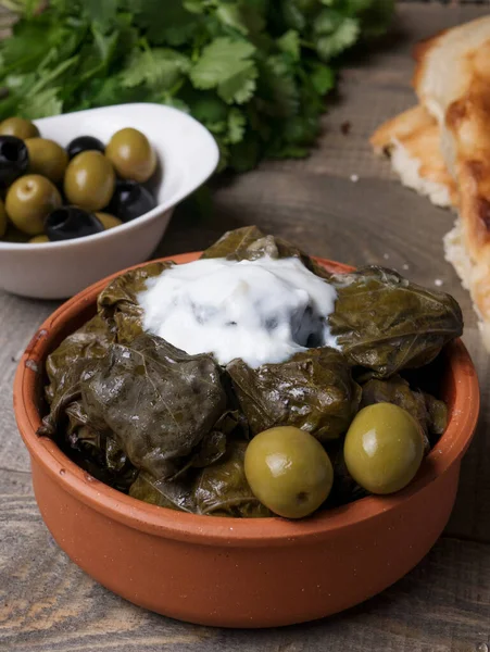 Geleneksel Azerbaijan dolması, kopyalanmış kırsal ahşap masa üzerinde üzüm yaprakları içinde. Doğu yemeği. Asma yapraklarındaki geleneksel Gürcü tolma, kopyalanmış kırsal arka planda. Türk yemeği