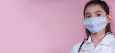 Doktor üniforması giyerken renkli steteskoplu komik bir kız. Renkli maske, panorama. çoklu uzay. Küçük bir doktor portresi. Kovid19. çözülebilir eldivenler 