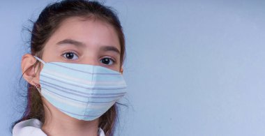 Doktor üniforması giyerken renkli steteskoplu komik bir kız. Renkli maske, panorama. çoklu uzay. Küçük bir doktor portresi. Kovid19. çözülebilir eldivenler 