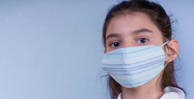 Doktor üniforması giyerken renkli steteskoplu komik bir kız. Renkli maske, panorama. çoklu uzay. Küçük bir doktor portresi. Kovid19. çözülebilir eldivenler 