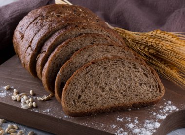 Tahta masada taze siyah ekmek. Ev yapımı ekşi ekmek hamuru, hasır sepetinde rustik ekmek. Ahşap masada taze pişmiş geleneksel ekmek.