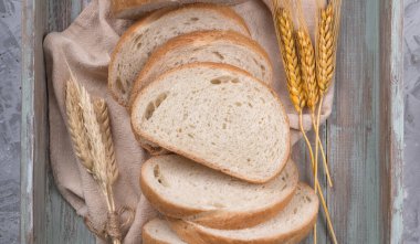 Gri arka planda eski ahşap tepside buğday unlu ev yapımı beyaz buğday ekmeği. Üst görünüm
