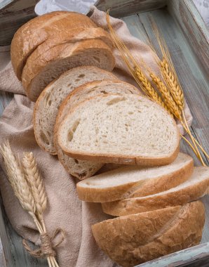 Gri arka planda eski ahşap tepside buğday unlu ev yapımı beyaz buğday ekmeği. Üst görünüm