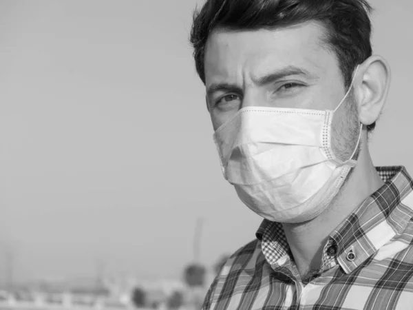 man wearing face mask during coronavirus outbreak. Virus spread flu prevention carantine. man in a facemask. disposable mask. stay safe . stop covid 19 . lockdown
