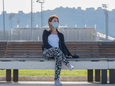 Coronavirüs salgını sırasında maske takan bir kadın. Virüs grip önleme karantinası yayılmış. Yüz maskeli bir kız. Tek kullanımlık maske. Kendine dikkat et. Kapatma 19. Kilitlenme