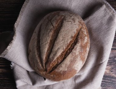 Siyah arka plandaki ahşap masada taze ekmek.