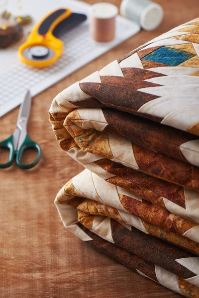 Gevouwen lappendeken deken op houten oppervlak op naaien accessoires achtergrond — Stockfoto