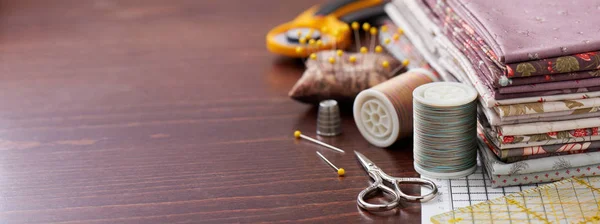 Pila di tessuto per patchwork su materassino artigianale, accessori per cucire su superficie in legno — Foto Stock