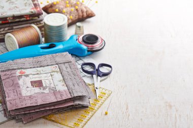 Patchwork günlük kabin blok, blok, dikiş aksesuarları Beyaz ahşap yüzeyde yığını