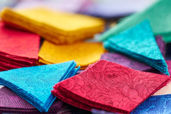 Pile stacks of triangle and diamond pieces of colorful bright fabrics for making quilt — Stock Photo, Image