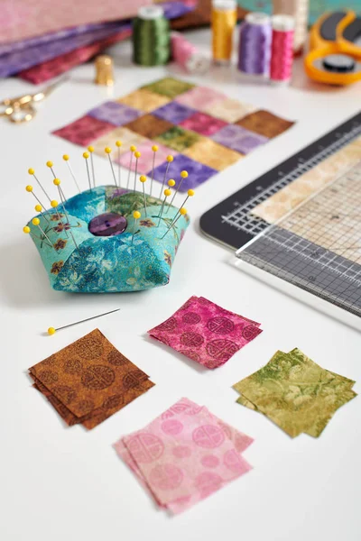 Fyrkantiga bitar av färgglada ljusa tyger för att göra täcke, pincushion, quiltblock, sömnad och quiltning tillbehör — Stockfoto