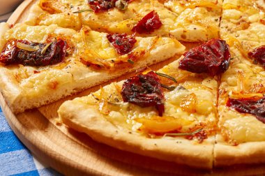 Kuru domates, soğan ve peynir ile pizza ahşap bir tabakta