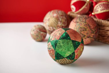 Patchwork bulmaca topları ve beyaz ve kırmızı arka plan üzerinde sepet Noel süslemeleri