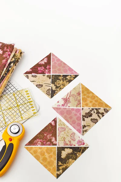 Preparación de piezas triangulares de telas para coser bloques de edredón, cortador rotativo, regla, alfombra artesanal, pila de telas —  Fotos de Stock