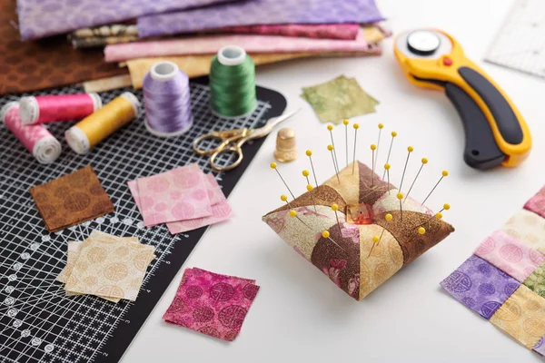 Pin cuscino, pile di pezzi quadrati di tessuto, pile di tessuti patchwork, trapuntatura e accessori per il cucito — Foto Stock