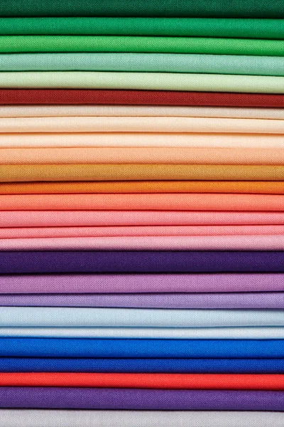 Stack of bright self-colored cotton fabrics as a background image — Stock Photo, Image