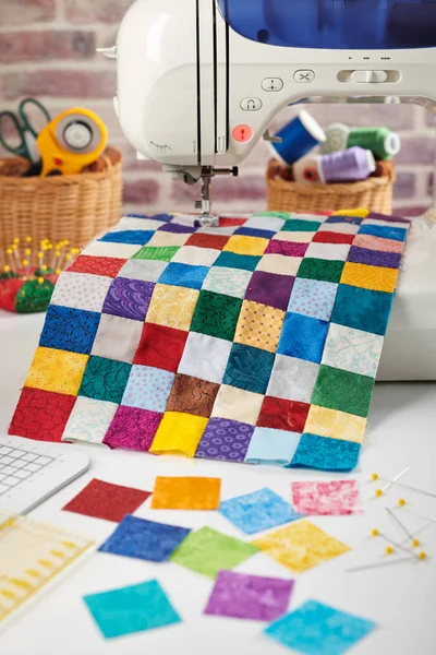 Kleurrijke detail van quilt genaaid van vierkante stukken op naaimachine, Quilten en naaien accessoires — Stockfoto