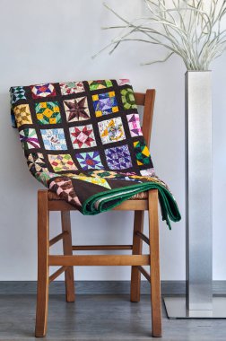 Tarafsız bir duvara karşı bir sandalye ve lamba üzerinde katlanmış yorgan.