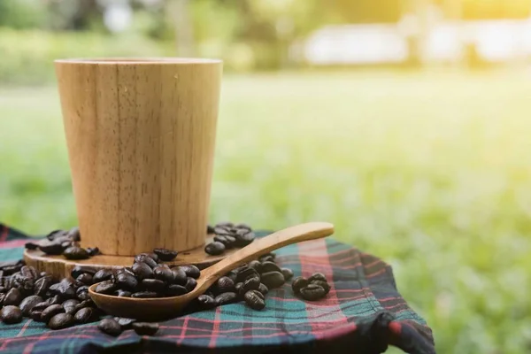 コーヒーと木製のスプーンの木製カップにコーヒー豆 — ストック写真