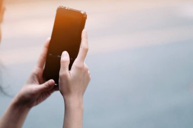 Sokakta siyah akıllı telefon kullanan bir kız 