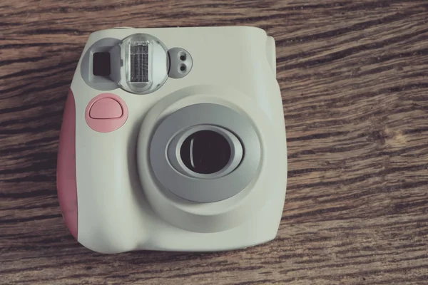 Eski ahşap doku arka planda beyaz anlık dijital fotoğraf makinesi 