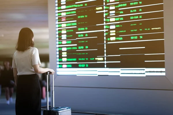 Podróżny dziewczyna sprawdzenie lotu na monitorze w porcie lotniczym — Zdjęcie stockowe