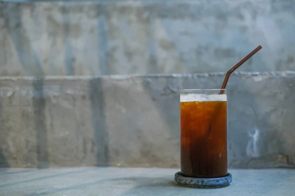 A glass of ice black coffee in cafe