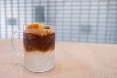 Bir bardak buzlu kahve ve portakal suyu. 