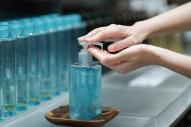 Elleri temizlemek için alkol jeli kullanan bir kız, COVID-19, yeni normal yaşam tarzı.