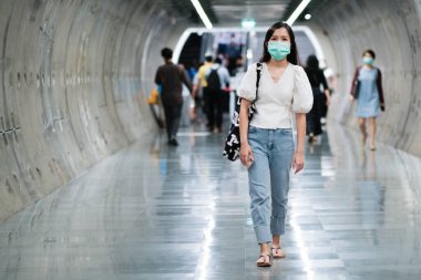 Asyalı kız halka açık alanlarda virüsü korumak için cerrahi maske takıyor. Yeni normal yaşam tarzı.