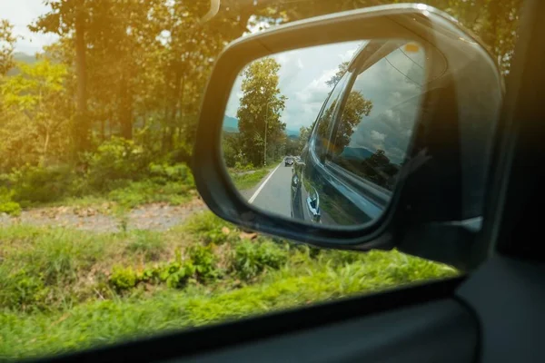 The view through the side mirrors of the car, Driving on vacation through the national park.