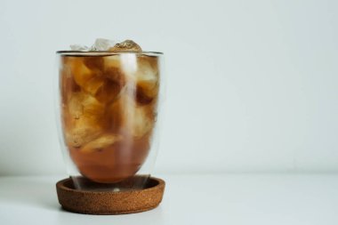 Beyaz masada bir bardak buzlu limon çayı. 