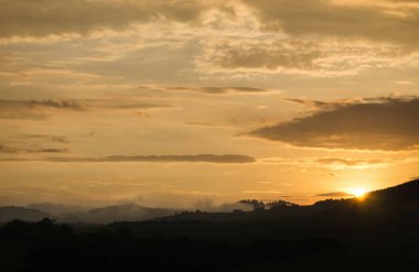 Dağlarda renkli bulutlu gün batımı  