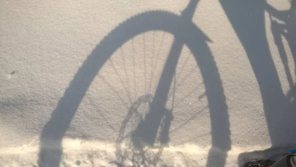 雪道の自転車ホイールのシルエット — ストック写真