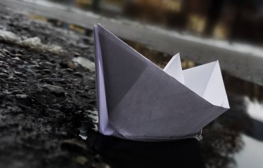 Bir su birikintisi içinde yüzen kağıt tekne