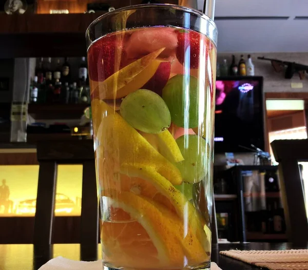 Big glass with fruits on table
