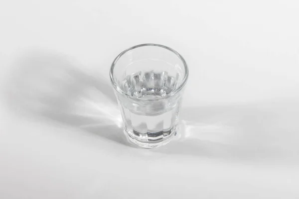 close up view of glass of water on light backdrop