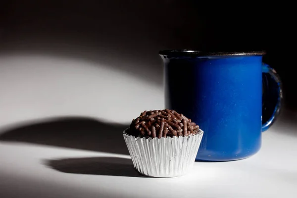 sweet dessert and cup of drink on black background