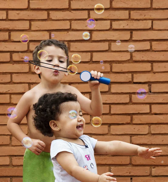 Бразильський Хлопчик Маленькою Сестрою Грає Мильними Бульбашками — стокове фото