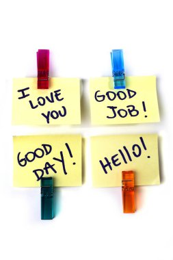 Seni seviyorum, iyi iş, iyi günler, merhaba mesajları beyaz bir arka plan üzerinde izole tutan bir clothespins ile sarı bir kağıt notlar üzerine yazılmış