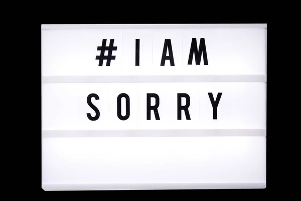 i am sorry text in a light box. Box isolated over black background. A sign with a message