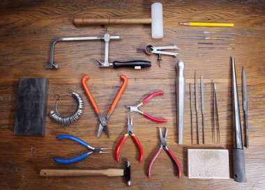 Kuyumcular takı işyerinde araçları üst görünümü. Profesyonel araçlar la zanaat takı yapmak için Masaüstü. Rustik ahşap arka plan üzerinde araç seti